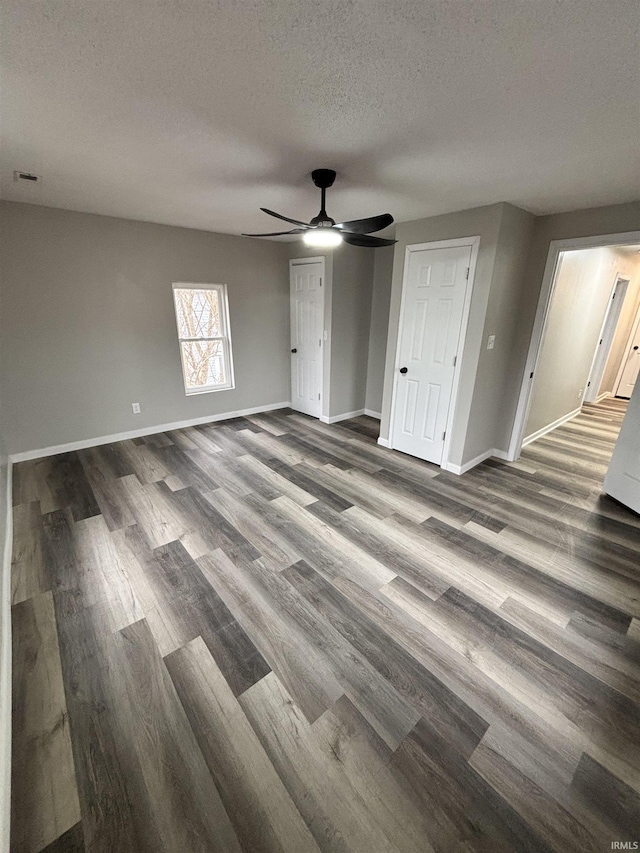 309 E S St, Eaton, IN 47338 - unfurnished bedroom with dark wood-type flooring, baseboards, a textured ceiling, and ceiling fan