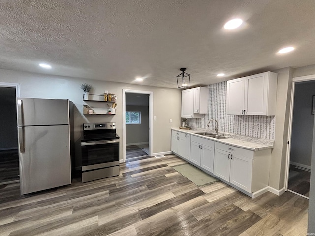 309 E S St, Eaton, IN 47338 - kitchen featuring stainless steel appliances, a sink, white cabinets, baseboards, and decorative backsplash