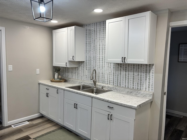 309 E S St, Eaton, IN 47338 - kitchen with a sink, light wood-style flooring, light countertops, baseboards, and a textured ceiling