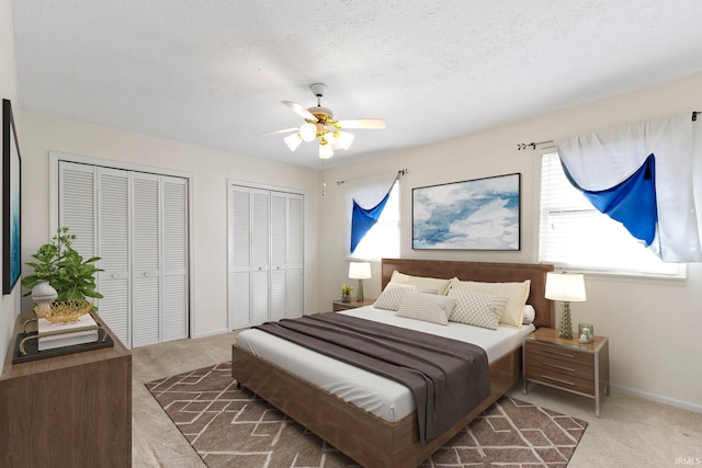 416 Maple St, Tipton, IN 46072 - carpeted bedroom with baseboards, two closets, ceiling fan, and a textured ceiling