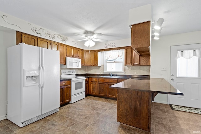 416 Maple St, Tipton, IN 46072 - kitchen featuring a peninsula, dark countertops, brown cabinets, and white appliances