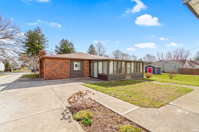 416 Maple St, Tipton, IN 46072 - view of front of home featuring concrete driveway, fence, a front yard, brick siding, and a chimney