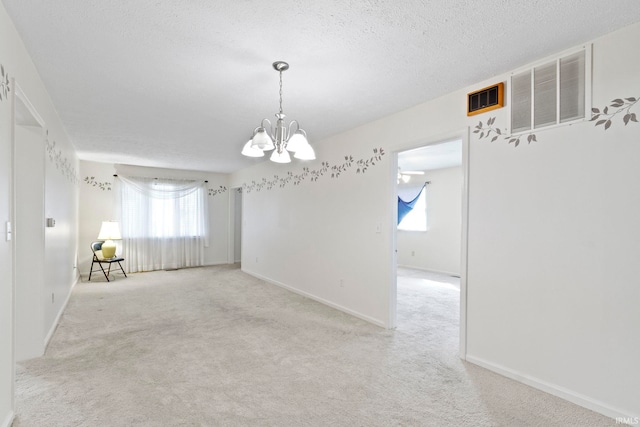 416 Maple St, Tipton, IN 46072 - unfurnished room with carpet flooring, a textured ceiling, visible vents, baseboards, and an inviting chandelier