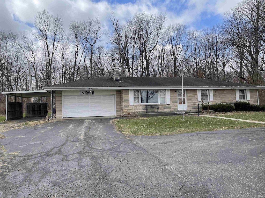 single story home with a front yard, a garage, stone siding, and aphalt driveway