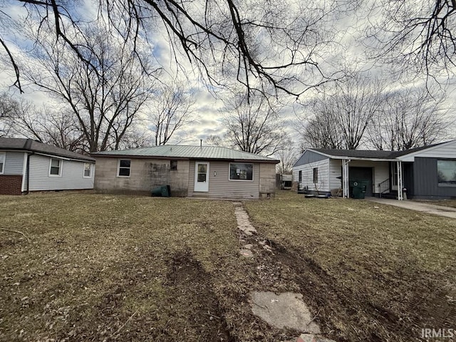back of property with a garage and a yard