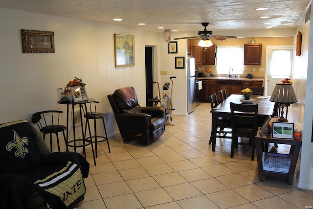 living area featuring a textured ceiling, baseboards, ceiling fan, recessed lighting, and light tile patterned floors