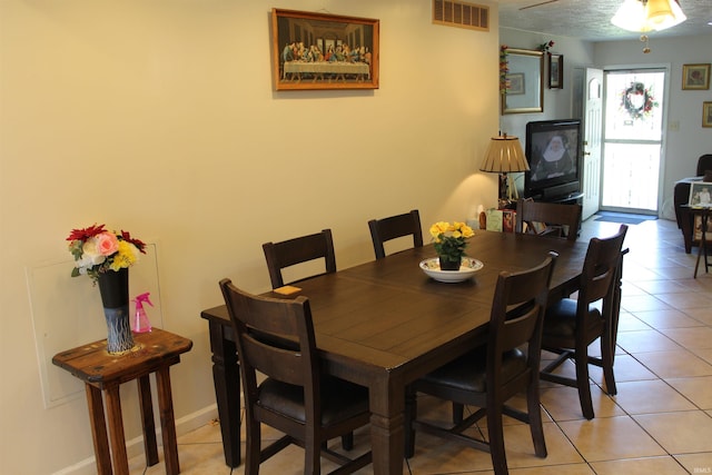 dining room with light tile patterned floors, baseboards, and visible vents