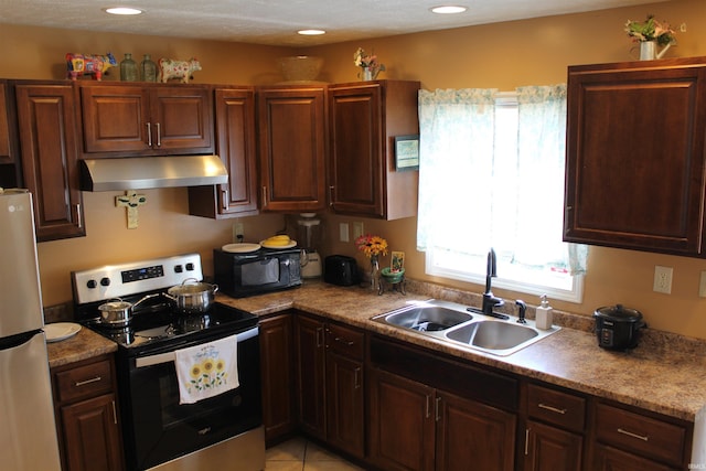 kitchen with light tile patterned flooring, recessed lighting, appliances with stainless steel finishes, under cabinet range hood, and a sink