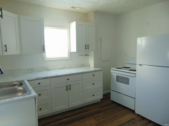 kitchen with white cabinets, a sink, dark wood finished floors, and white appliances