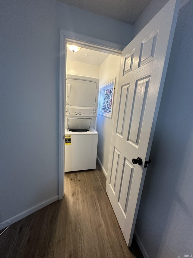 112 W Bond St, Attica, IN 47918 - corridor featuring stacked washer and clothes dryer, baseboards, and wood finished floors
