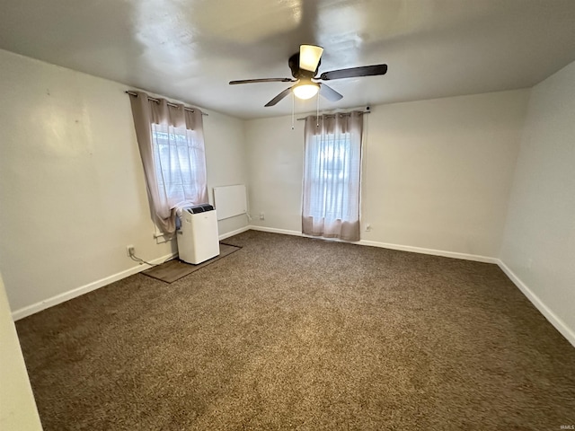 112 W Bond St, Attica, IN 47918 - spare room featuring baseboards, ceiling fan, dark carpet, and a healthy amount of sunlight