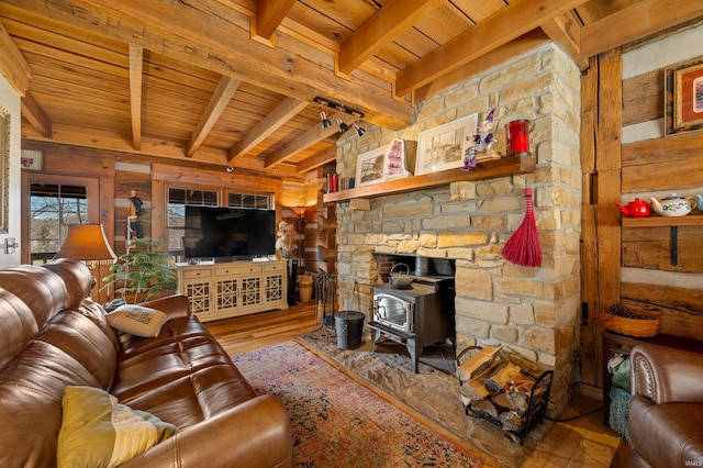 5175 Beanblossom Rd, Nashville, IN 47448 - living room featuring beamed ceiling, wood finished floors, wooden ceiling, and a wood stove