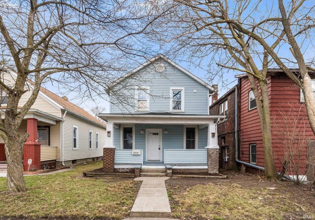 view of front of property featuring covered porch and a front lawn