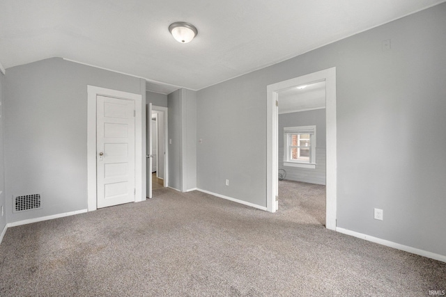 unfurnished bedroom with carpet, baseboards, lofted ceiling, and visible vents