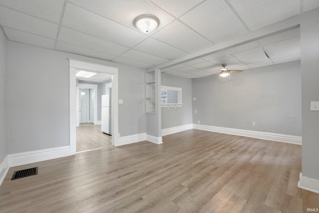 unfurnished room with visible vents, baseboards, ceiling fan, and wood finished floors
