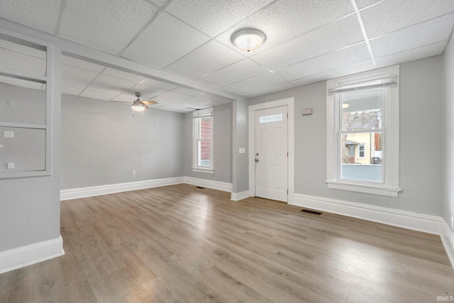 foyer entrance with visible vents, baseboards, ceiling fan, and wood finished floors