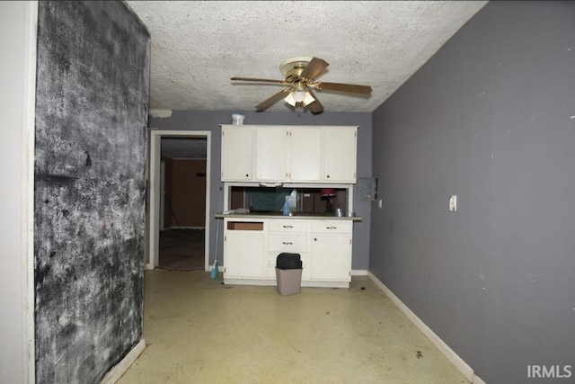 1620 Shelby Ave, Evansville, IN 47714 - kitchen featuring a ceiling fan, light floors, a textured ceiling, baseboards, and white cabinets