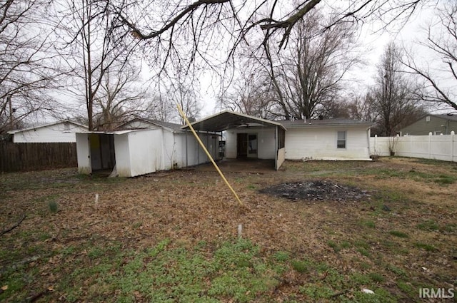 1620 Shelby Ave, Evansville, IN 47714 - rear view of house with a fenced backyard, an outbuilding, a storage unit, and a carport