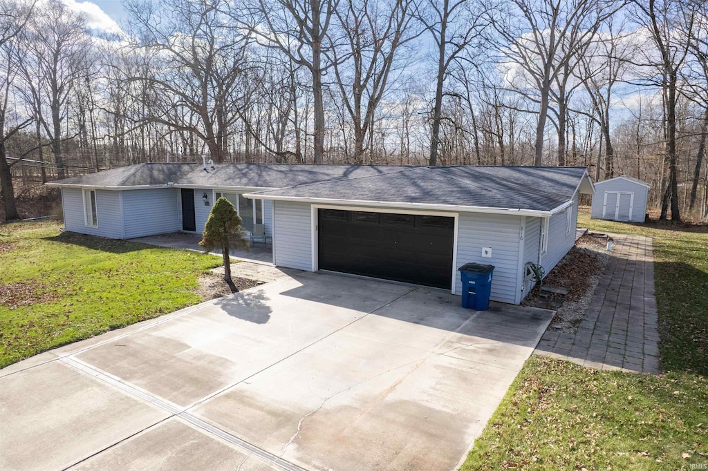 ranch-style home featuring a front yard, a storage unit, driveway, an outbuilding, and a shingled roof