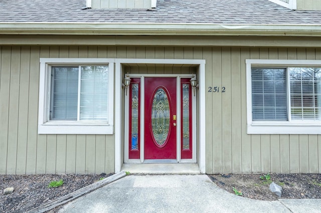 entrance to property featuring roof with shingles
