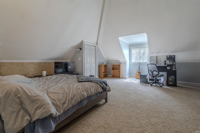 bedroom with vaulted ceiling, a closet, carpet, baseboards, and ornamental molding