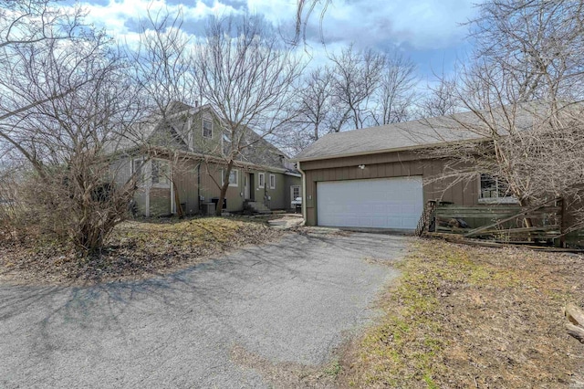 view of front facade featuring an attached garage and aphalt driveway
