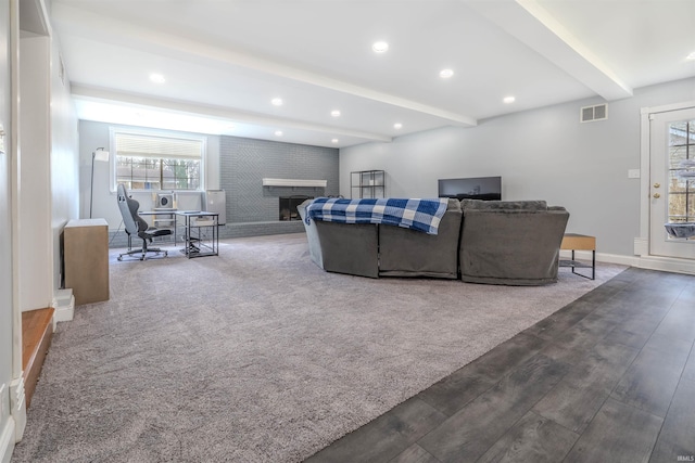 carpeted living area featuring recessed lighting, baseboards, beamed ceiling, visible vents, and a fireplace