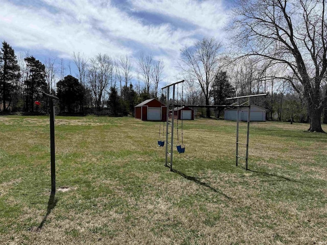 view of yard with a detached garage and an outbuilding