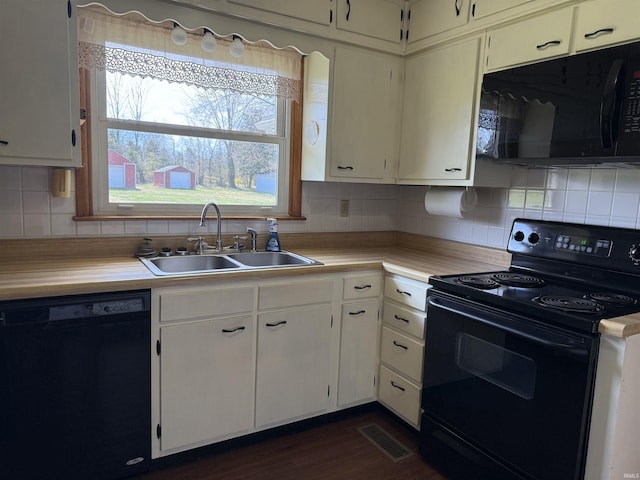 kitchen with light countertops, visible vents, a sink, black appliances, and backsplash