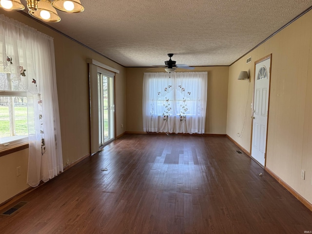 unfurnished dining area featuring dark wood-style flooring, visible vents, a healthy amount of sunlight, and ceiling fan