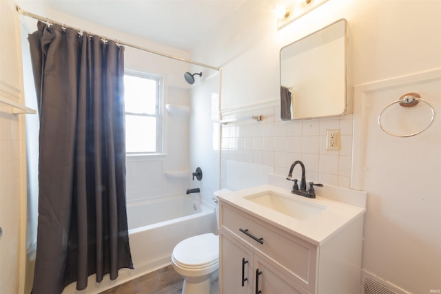 full bath with tile walls, toilet, vanity, tasteful backsplash, and shower / tub combo