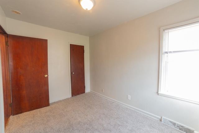 unfurnished bedroom with baseboards, visible vents, and carpet floors