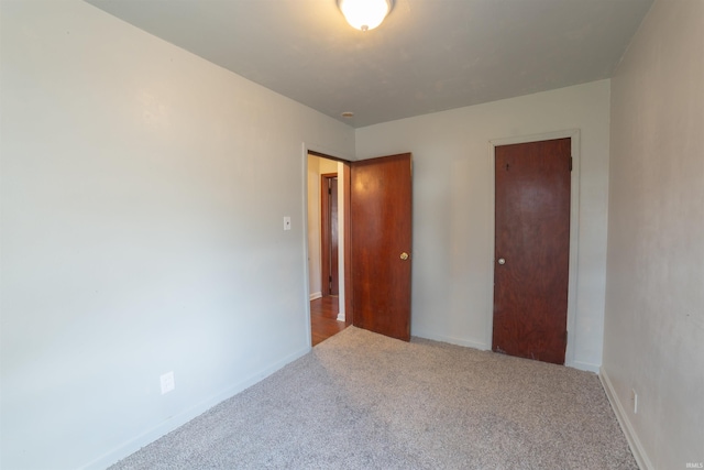unfurnished bedroom with carpet flooring and baseboards