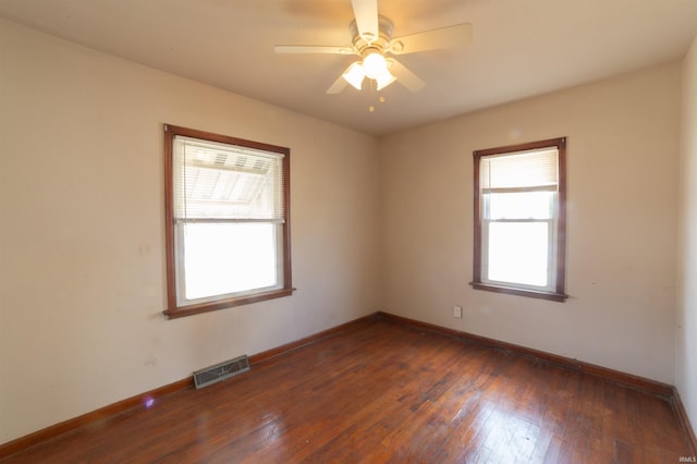 empty room featuring hardwood / wood-style floors, baseboards, ceiling fan, and visible vents