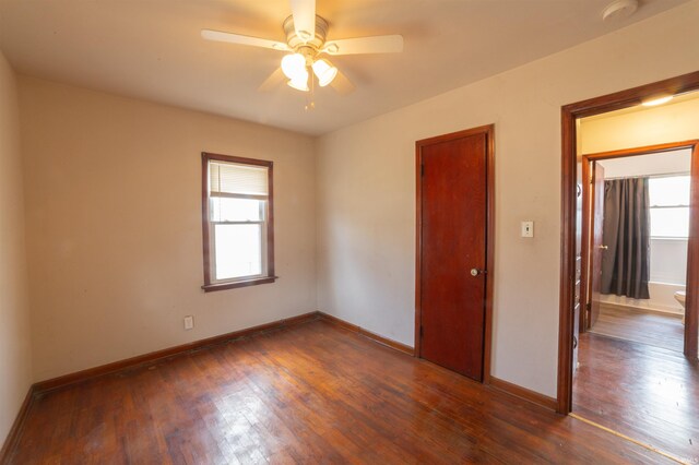 unfurnished room with baseboards, a ceiling fan, and dark wood finished floors