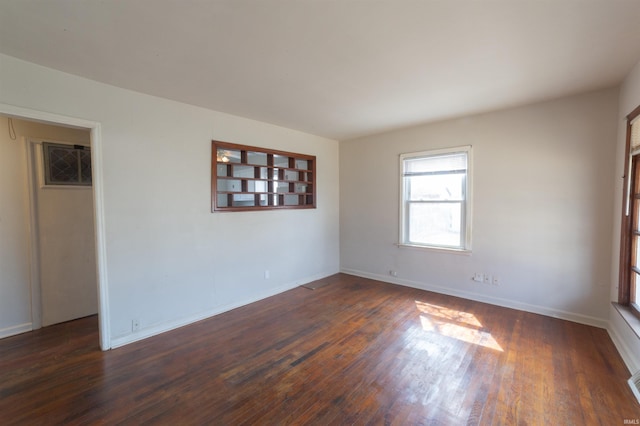 unfurnished room featuring baseboards and dark wood-style flooring