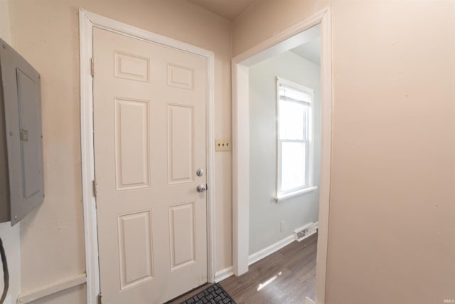 foyer entrance featuring electric panel, baseboards, visible vents, and wood finished floors