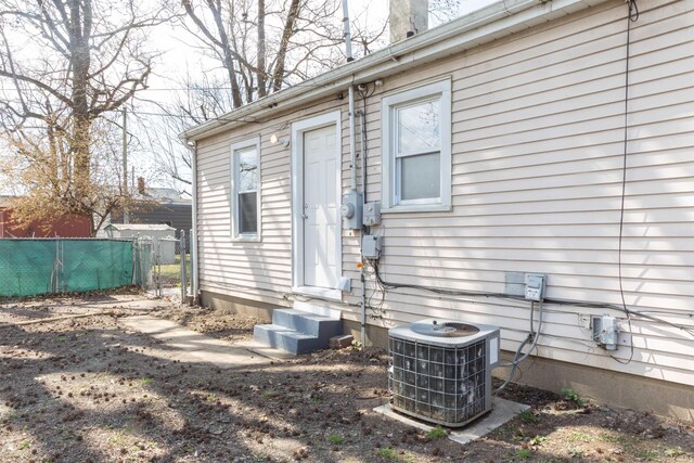 property entrance featuring central AC unit and fence