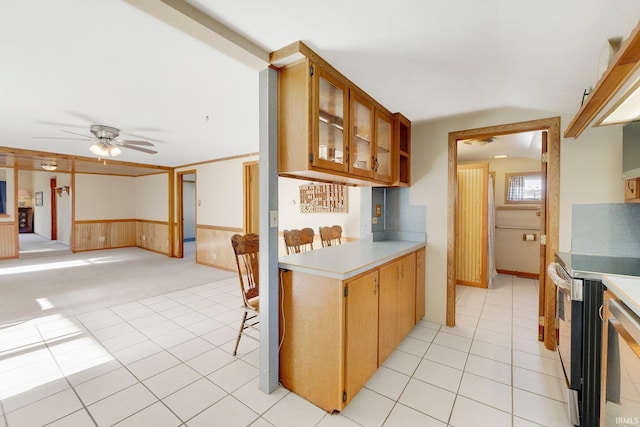 5540 N Willow Ave, Columbia City, IN 46725 - kitchen featuring a wainscoted wall, light countertops, ceiling fan, and electric range
