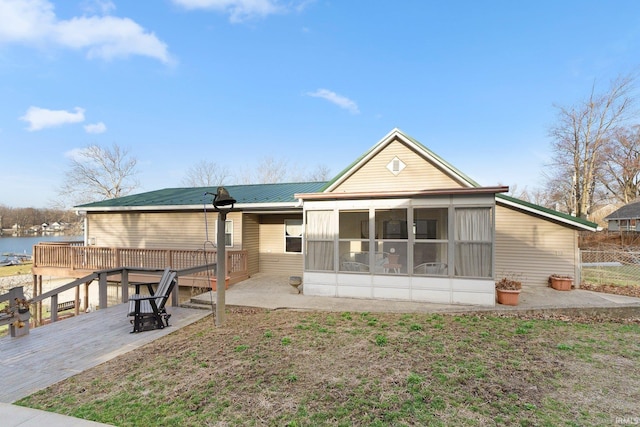 5540 N Willow Ave, Columbia City, IN 46725 - back of property with a deck with water view, a sunroom, fence, and metal roof