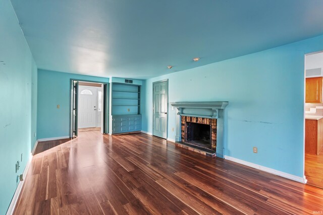 3323 Kiowa Ct, Fort Wayne, IN 46815 - unfurnished living room featuring baseboards, a fireplace, visible vents, and wood finished floors