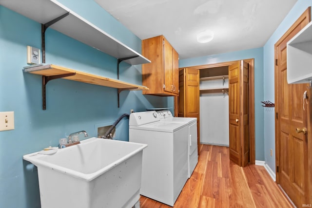 3323 Kiowa Ct, Fort Wayne, IN 46815 - laundry area featuring a sink, light wood finished floors, baseboards, independent washer and dryer, and cabinet space