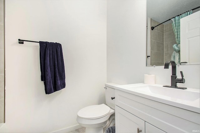 bathroom with baseboards, toilet, and vanity