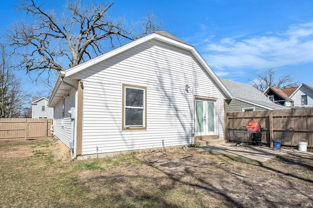 rear view of house featuring a fenced backyard, a patio, french doors, and a yard