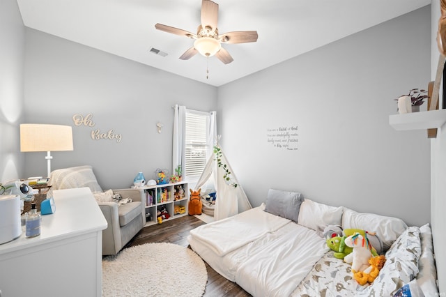 bedroom with visible vents, wood finished floors, and a ceiling fan