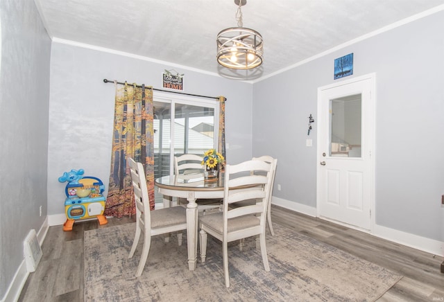 908 S Main St, Kendallville, IN 46755 - dining space featuring an inviting chandelier, ornamental molding, baseboards, and wood finished floors