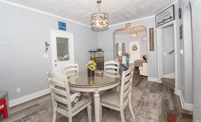 908 S Main St, Kendallville, IN 46755 - dining room with ornamental molding, arched walkways, baseboards, and wood finished floors