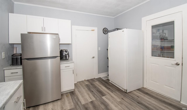 908 S Main St, Kendallville, IN 46755 - kitchen featuring light countertops, white cabinets, and freestanding refrigerator