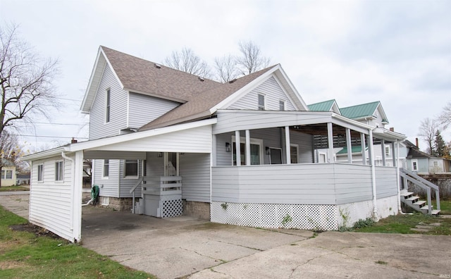 908 S Main St, Kendallville, IN 46755 - view of front of house featuring concrete driveway, a porch, roof with shingles, and a carport
