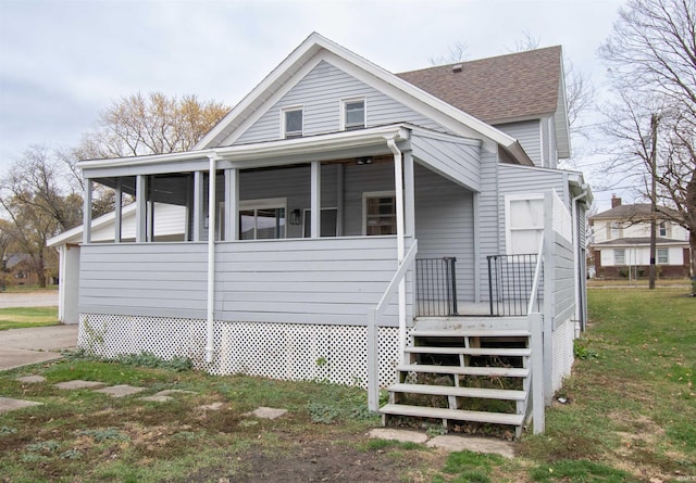 908 S Main St, Kendallville, IN 46755 - view of front facade featuring a sunroom, a front lawn, stairway, and roof with shingles